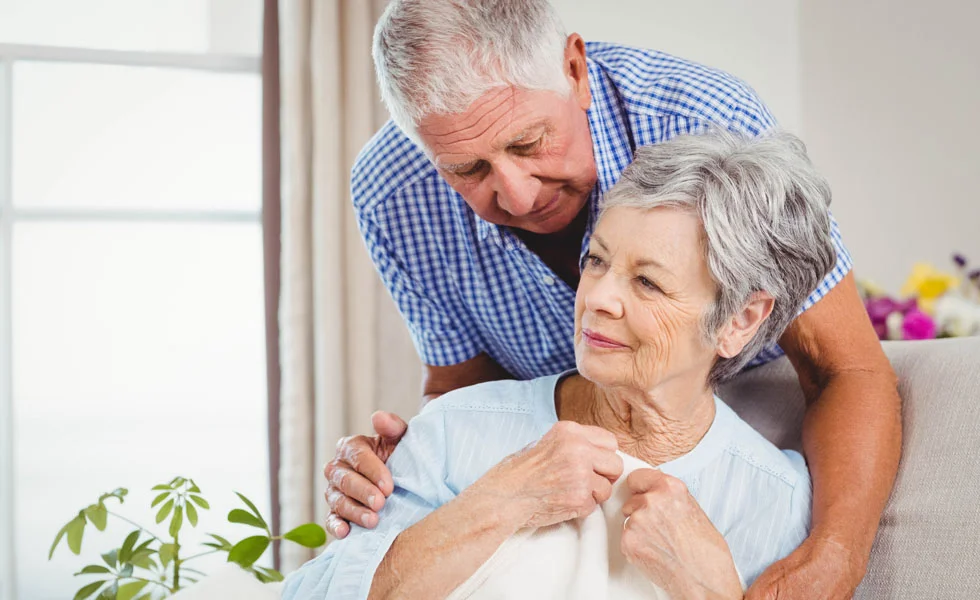 Elderly couple looking out of window