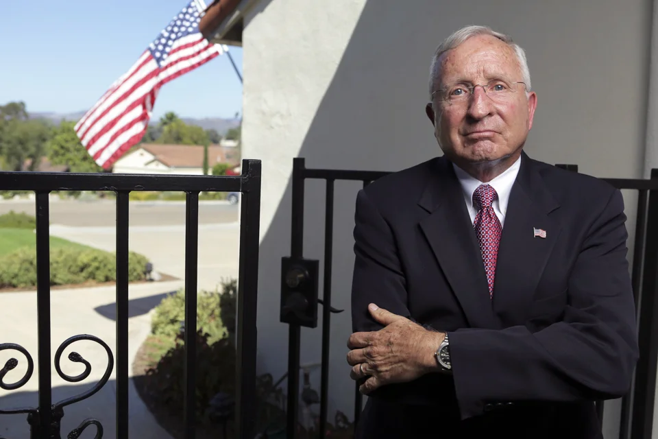 Art Pfizenmayer crossing arms with house a in background