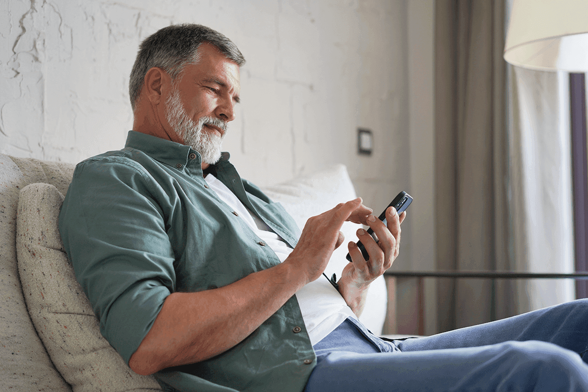 Man using mobile phone while sitting on couch