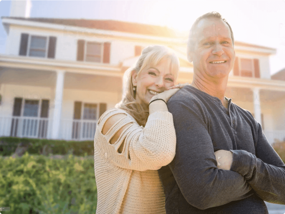 Couple smiling in front of house